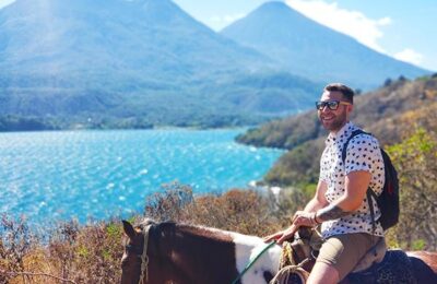 Man Riding a Horse with Volcanos at the Back